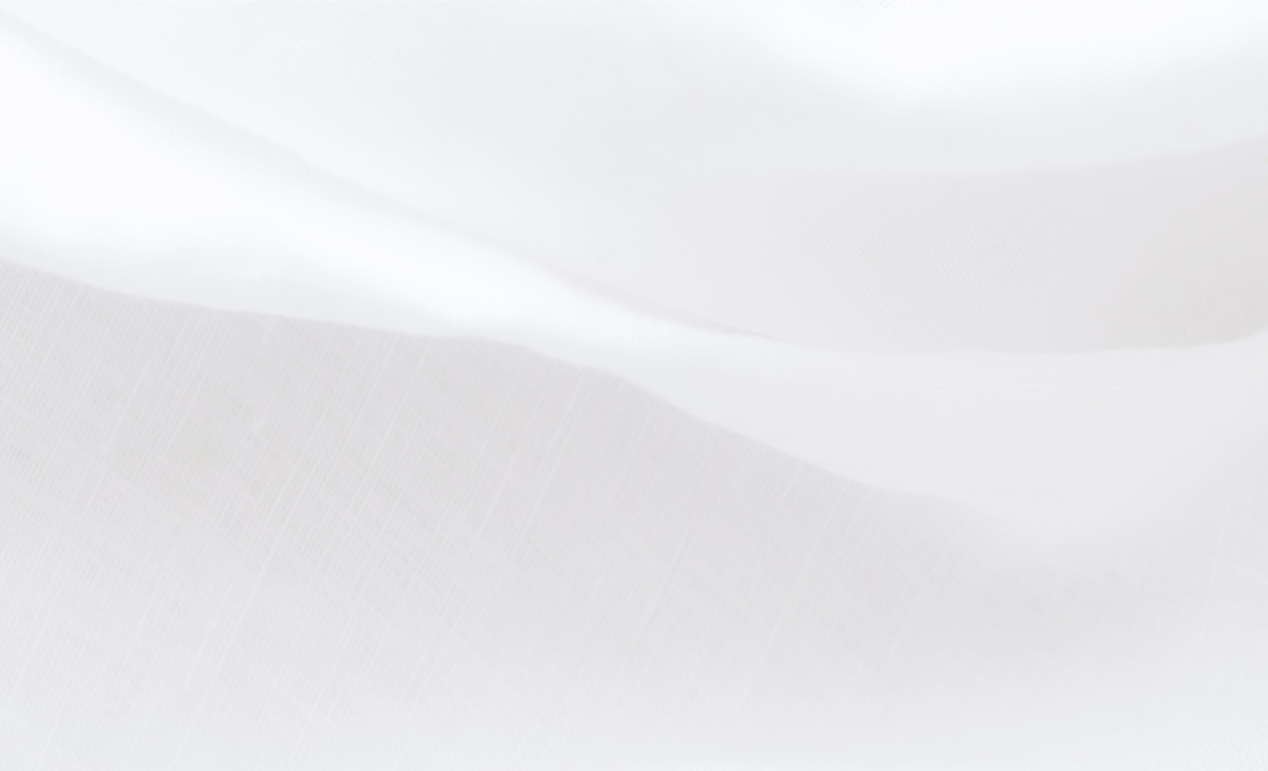 Soft, textured white fabric background close-up.