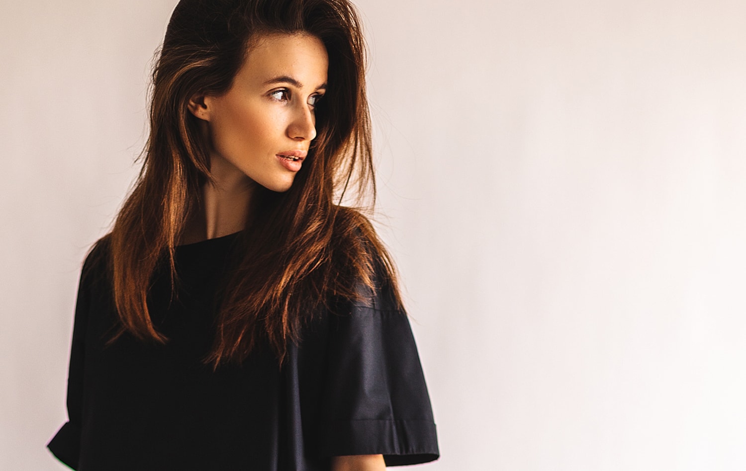 Young woman with long hair in black top.