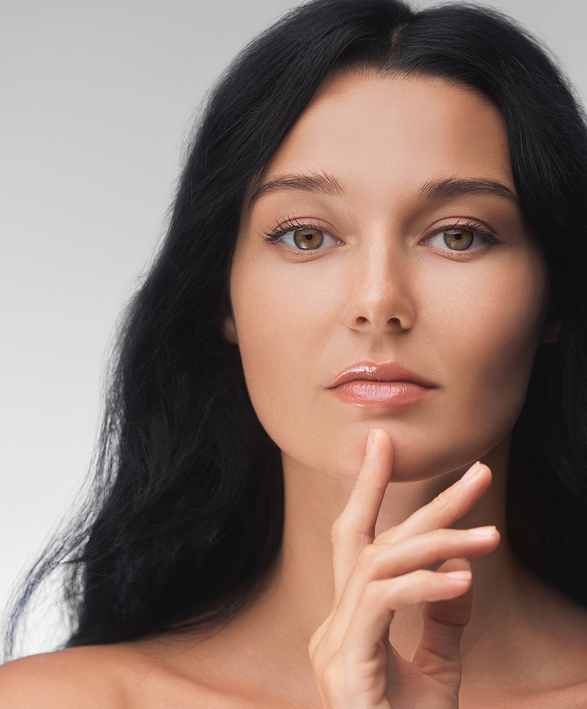 Woman with long dark hair and thoughtful expression.