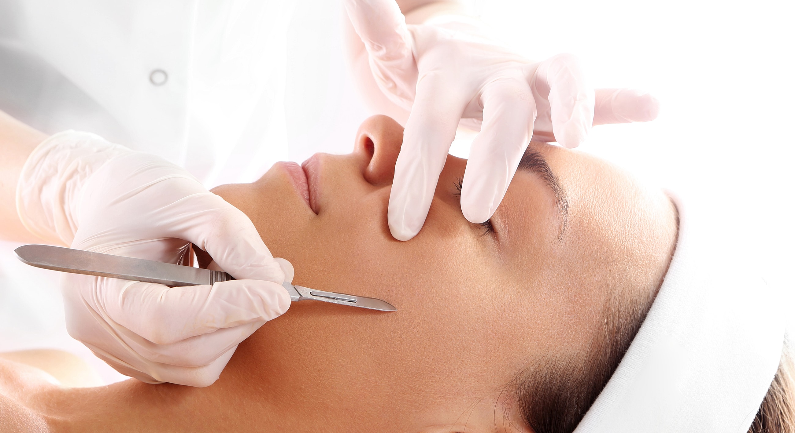 Facial treatment with scalpel and gloves.